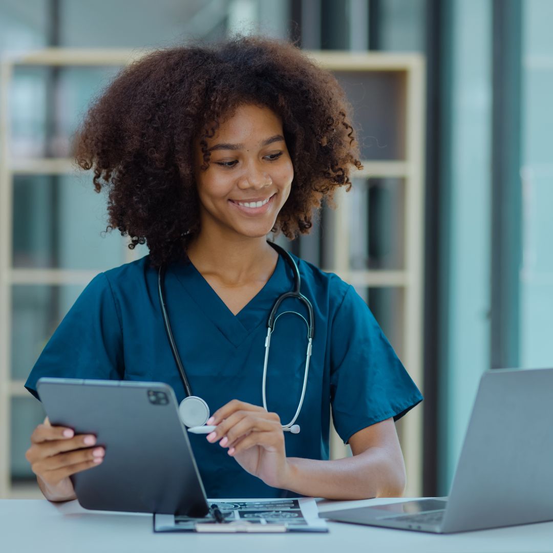 EKG technician holding a tablet, looking at computer