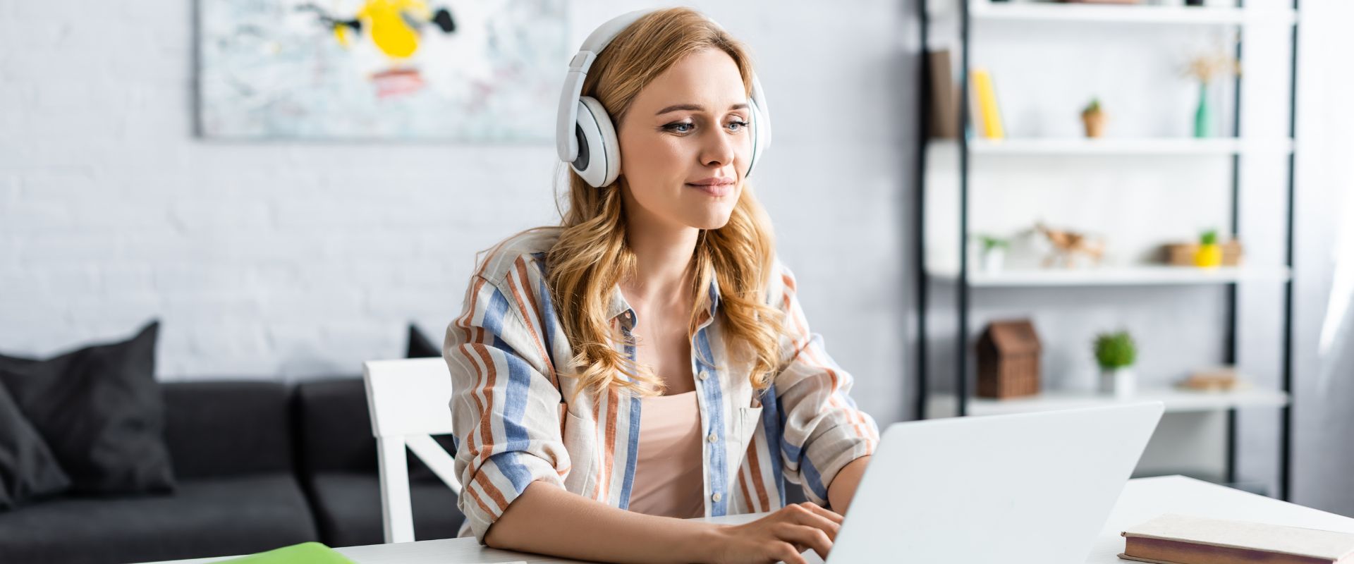 eLearning designer wearing headphones and working on computer