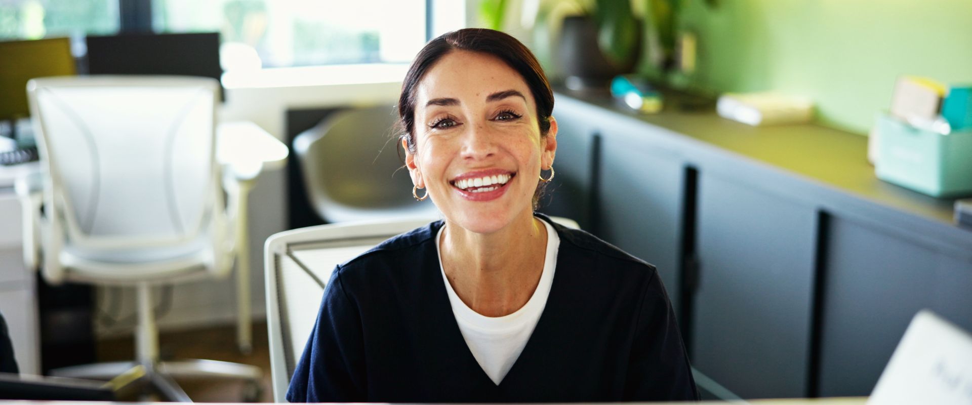 Medical administrative assistant looks up from her desk