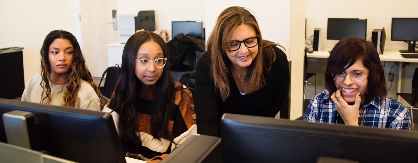 Computer science teacher working with students