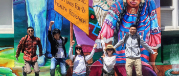 International student jump up in front of the Women's Building mural